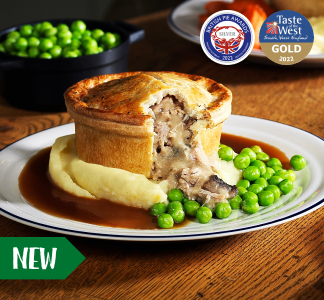 Table Table menu item of Chicken and Mushroom Pie on a plate with gravy, peas and mashed potatoes.
